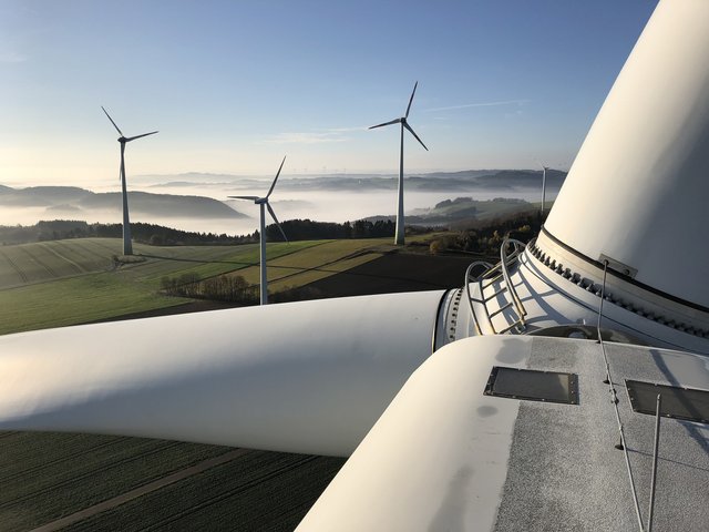 Blick von einem Windrad aus auf eine Windenergieanlage