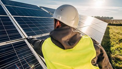 Arbeiter prüft Photovoltaikanlage
